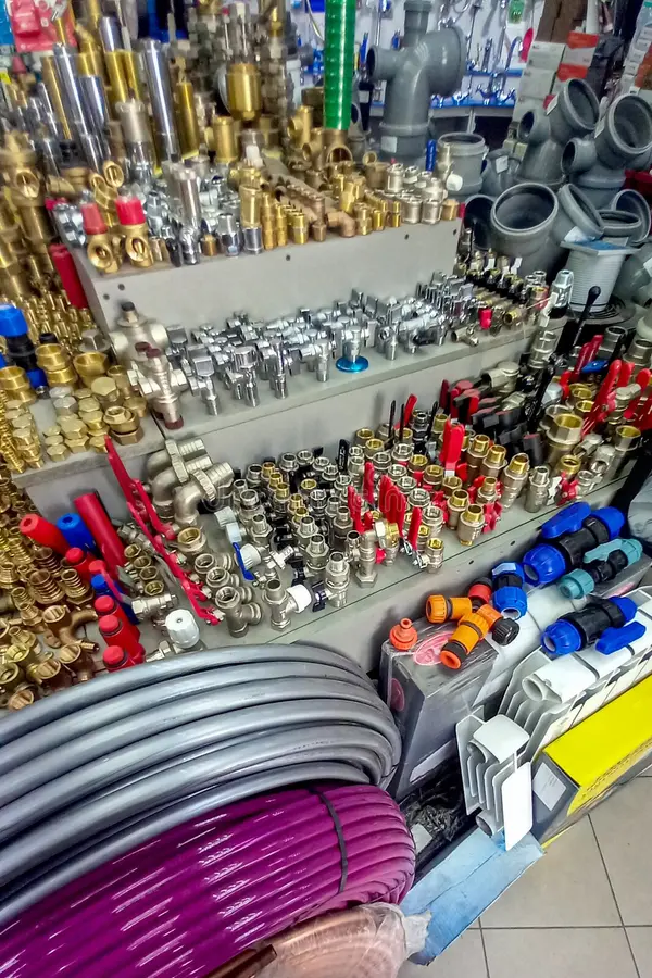 assortment plumbing supplies hardware store including fittings valves pipes connectors hoses tools various metal plastic 404398086